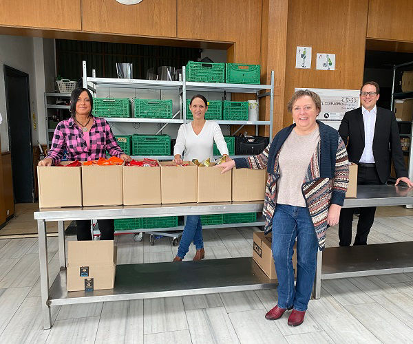Vier Personen stehen vor einem Tisch