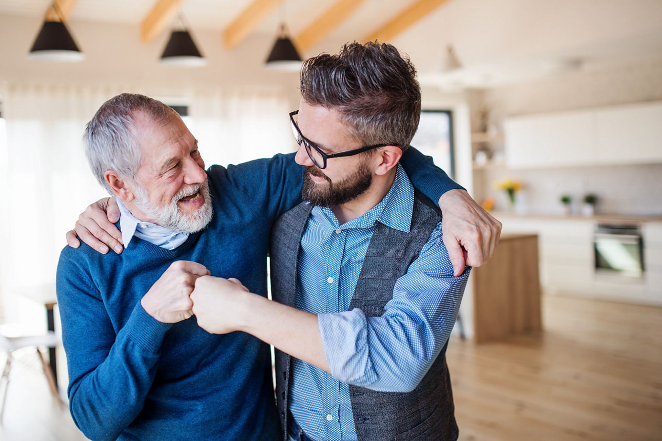 Zwei Männer haben die Arme umeinander gelegt und begrüßen sich