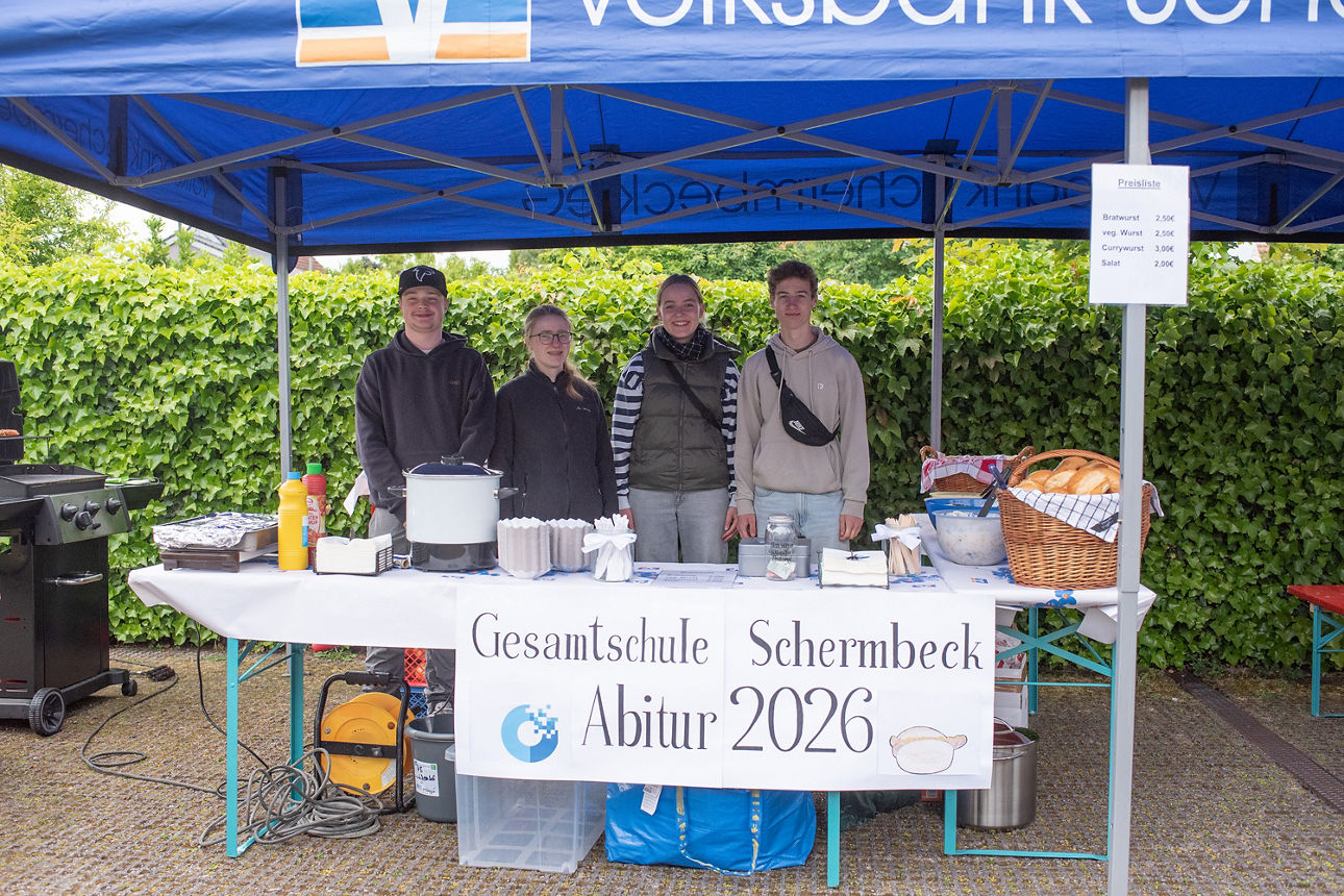 Vier Abiturienten hinter einem Verkaufsstand