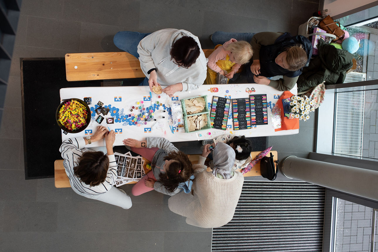 Vogelperspektive: Sechs Personen an einem Basteltisch