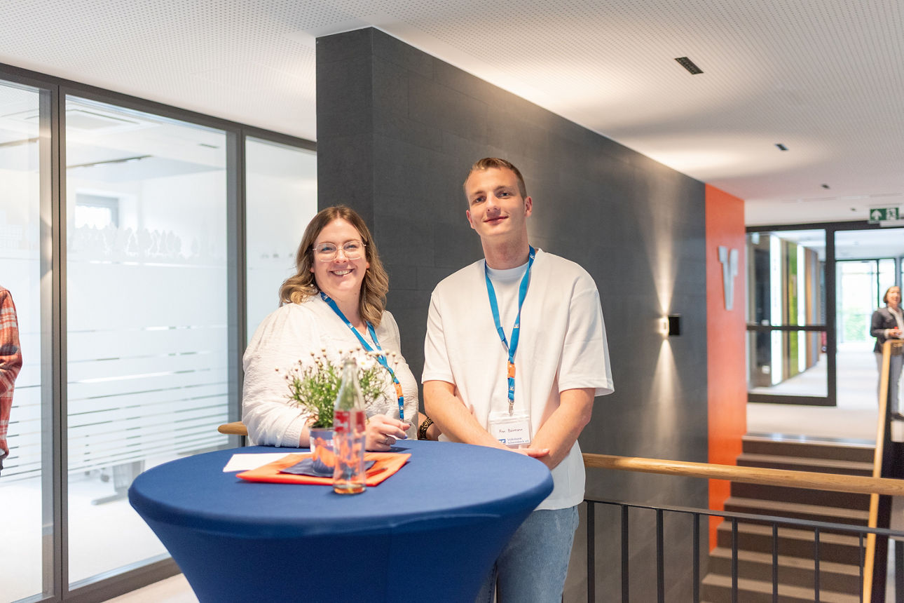 Zwei Mitarbeiter der Volksbank Schermbeck an einem Stehtisch
