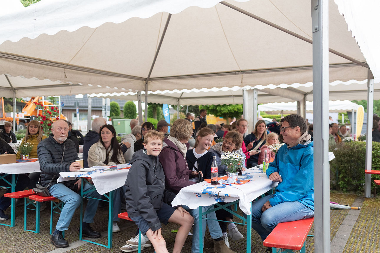 Personenmenge an Tischen unter Pavillion