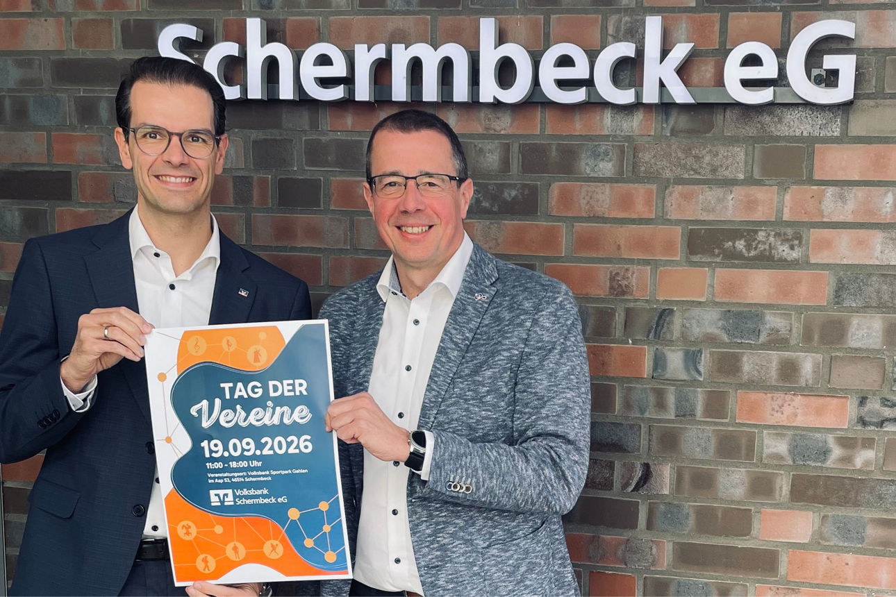 Die beiden Vorstände stehen vor einer Wand und halten ein Bild zum Tag der Vereine hoch