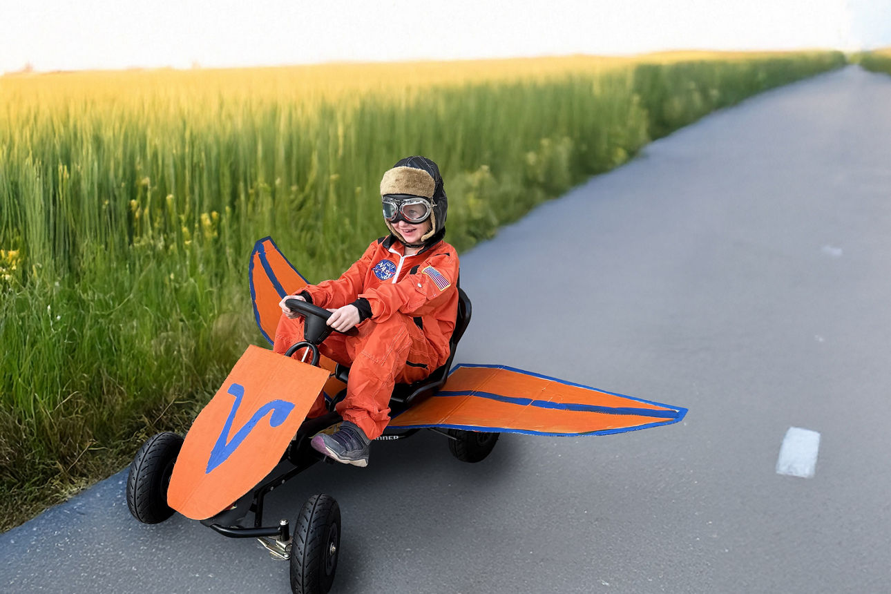 Ein Kind auf einem Go- Kart auf einem Feldweg. 