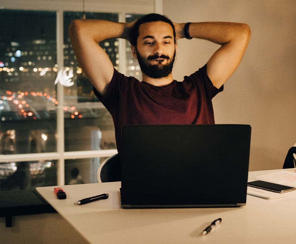 Mann sitzt vor einem Laptop