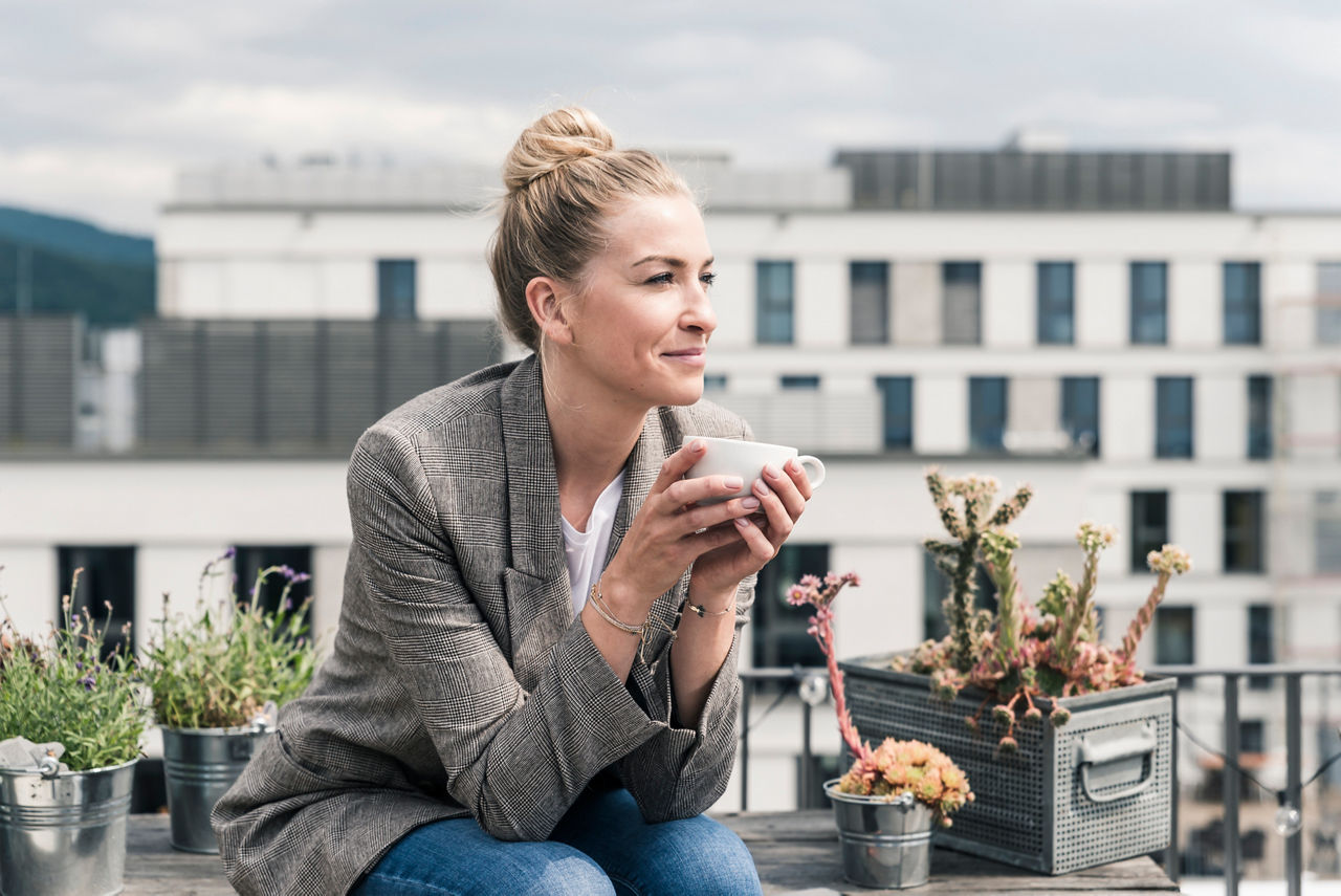 Abbildung einer Dame, die gerade auf einer Dachterrasse ihren Tee genießt
