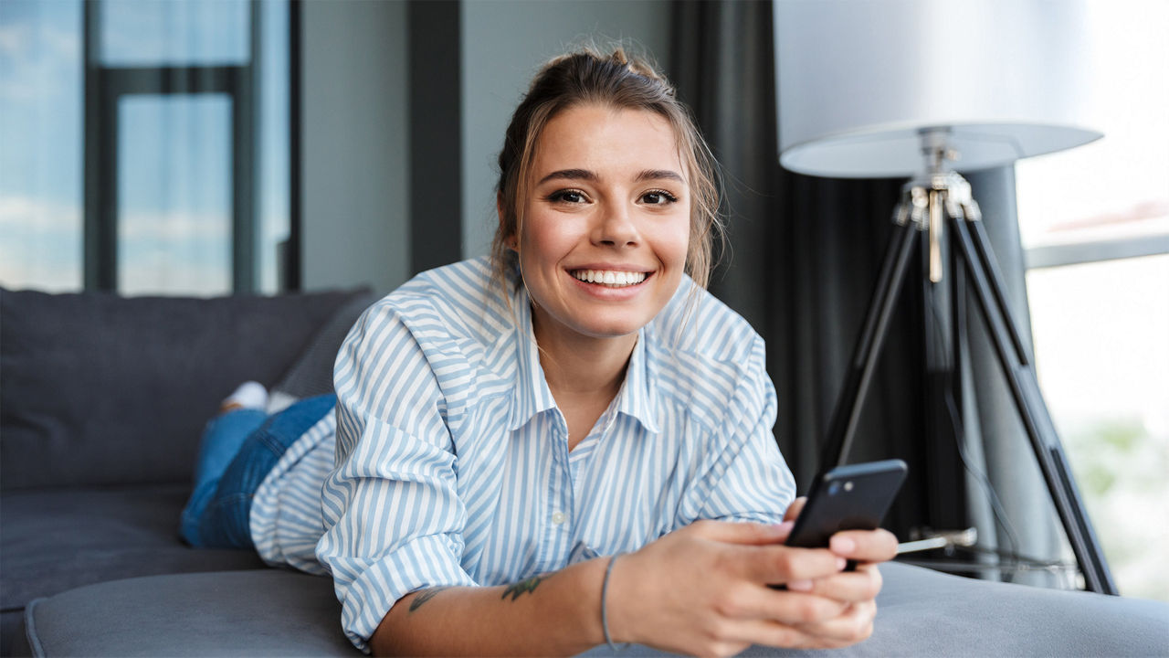 Frau auf dem Sofa mit Handy