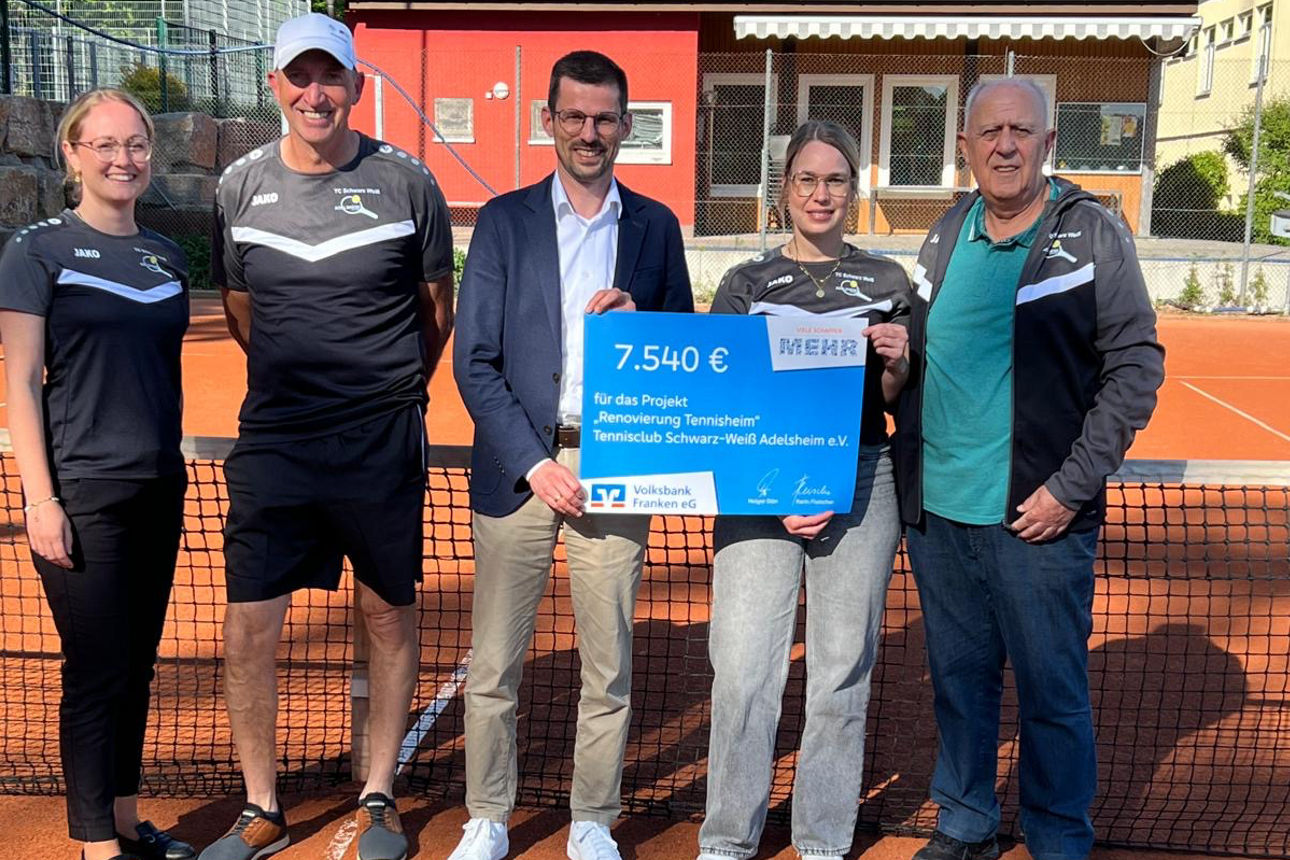 Fünf Menschen stehen auf einem Tennisplatz und halten einen großen Spendenscheck.