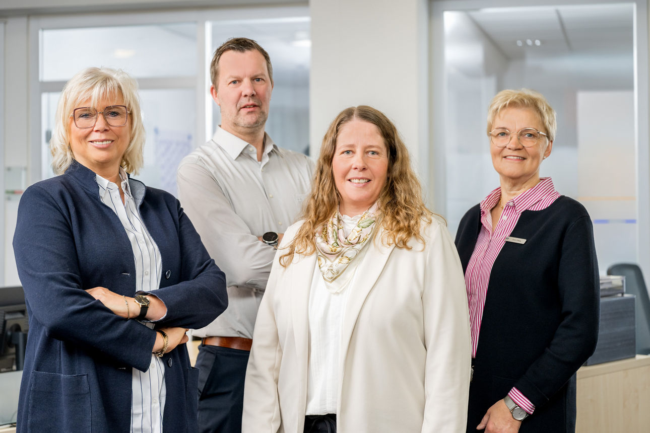 Vier Personen schauen in die Kamera