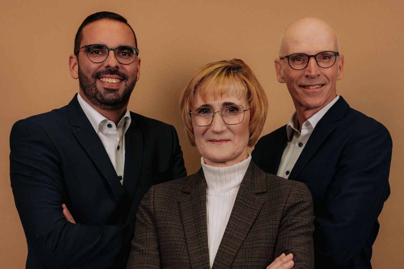 Zwei Männer und zwei Frauen stehen lächelnd nebeneinander