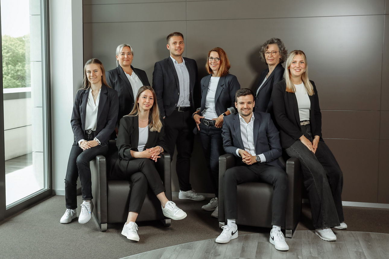 Gruppenbild VBI sitzend und stehend vor dunkler Wand