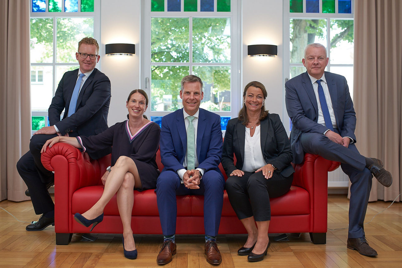 Drei Männer und zwei Damen im Anzug: Team Werther und Ernst  