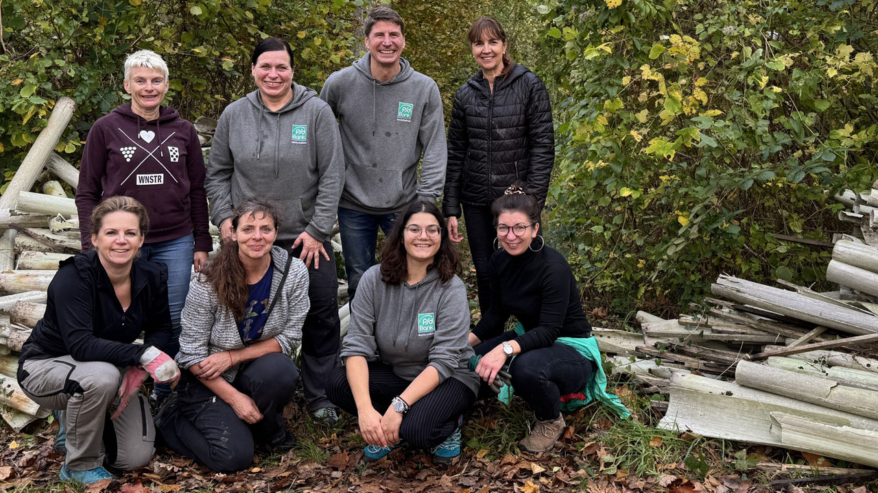 Acht Mitarbeitende der PSD Bank posieren neben den entfernten Wuchshüllen.