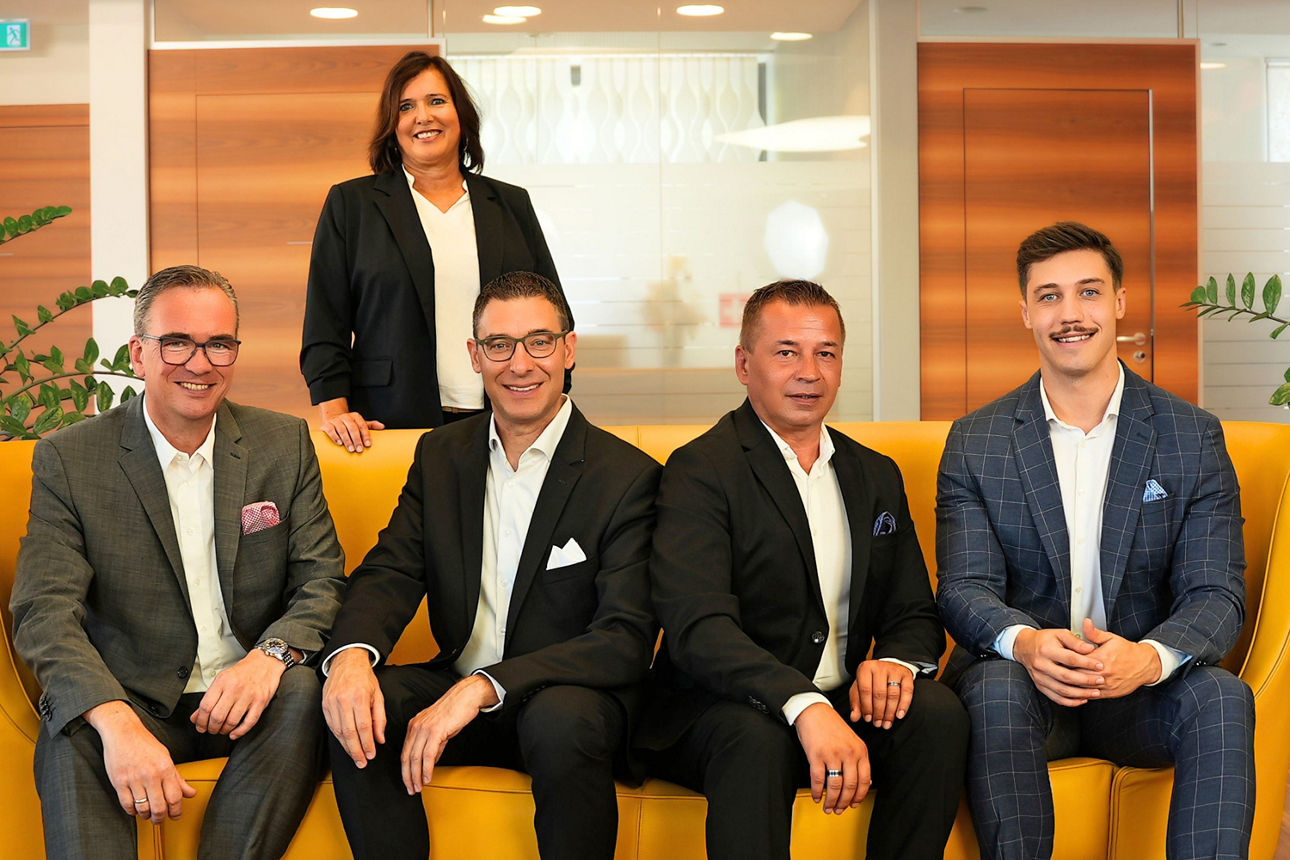 Das Private Banking Team der VR SüdBank eG. Frauen und Männer in Business-Kleidung sitzen in einem modernen Foyer.