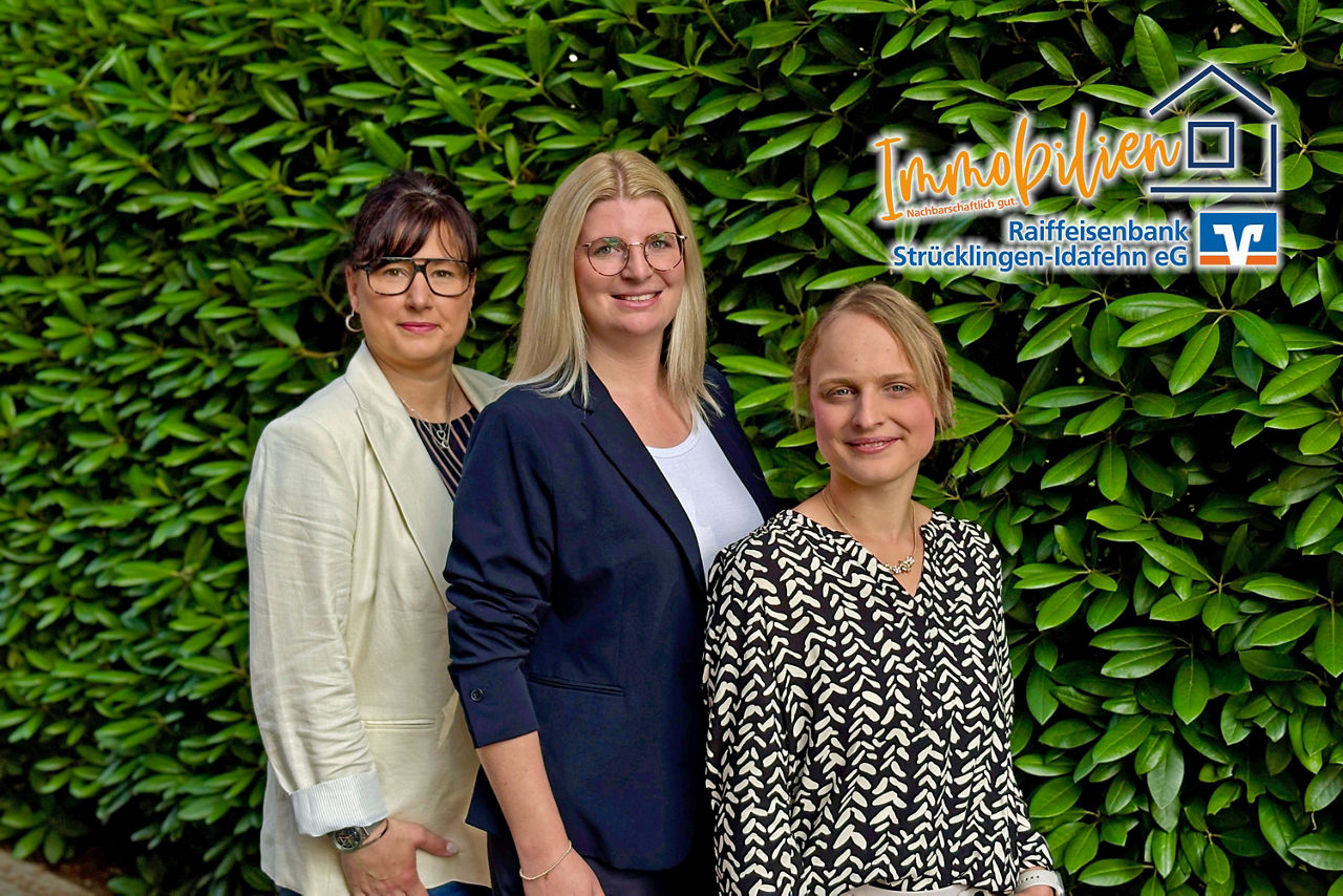 Drei junge Frauen vor einer grünen Hecke