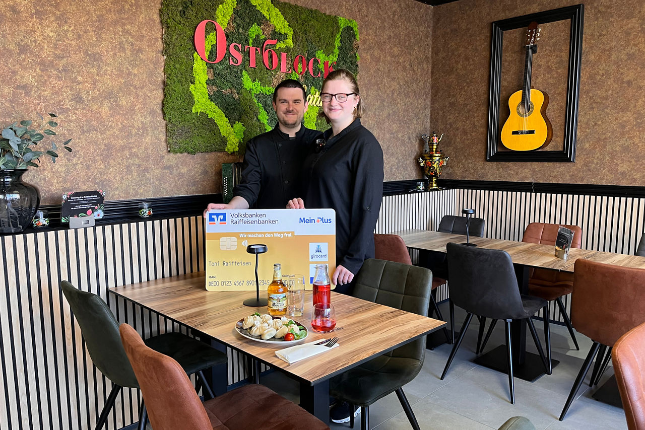 Zwei Personen im Restaurant mit einer Bankkarte in der Hand