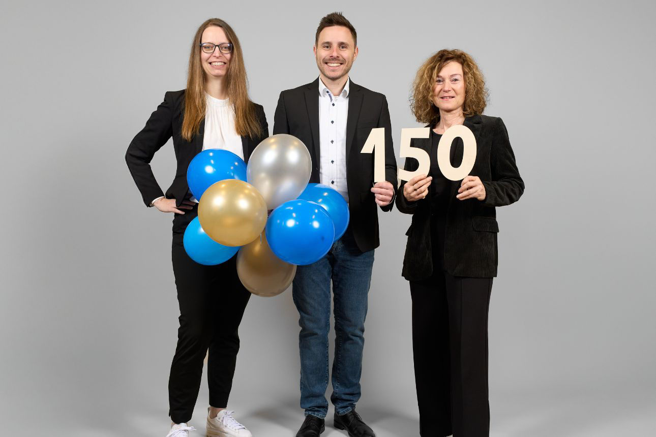 3 Personen mit Luftballon und 150 Jahre Schild