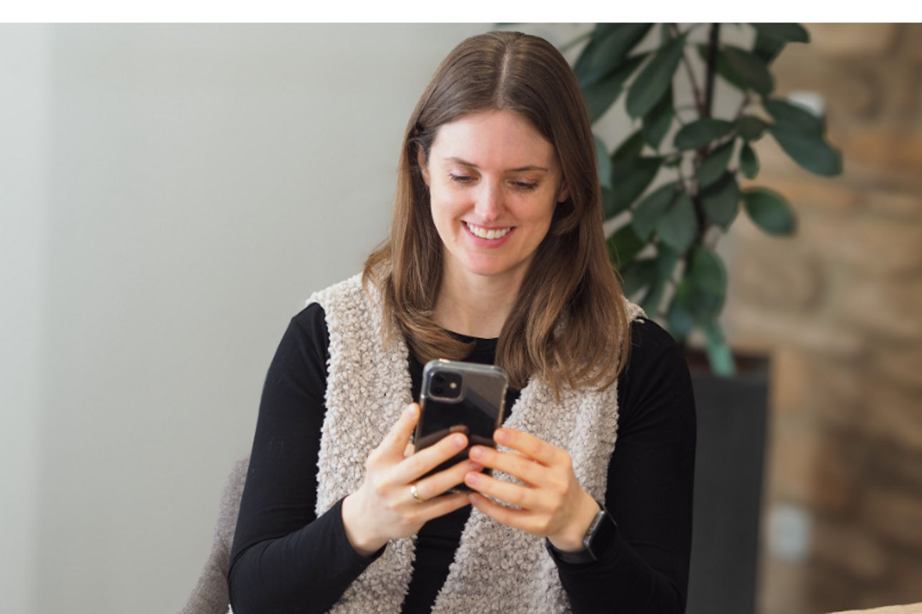 Eine Frau, die auf ihr Handy schaut.