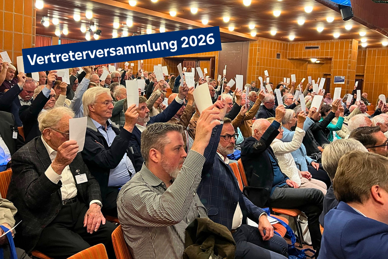Text: Vertreterversammlung 2026 - Motiv: Personen halten Stimmzettel hoch