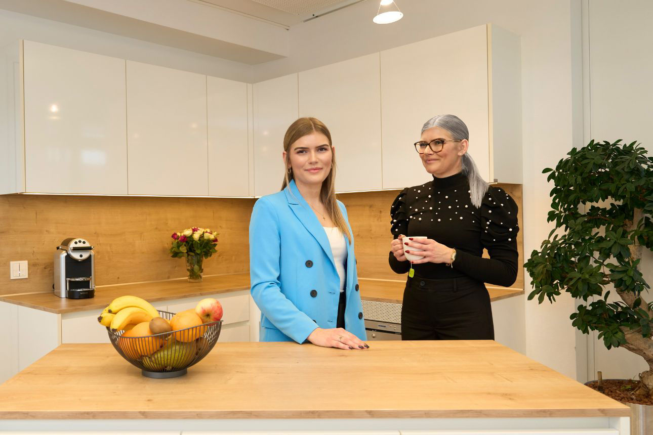 Eine junge Frau im Vordergrund und eine ältere Frau im Hintergrund tanzen