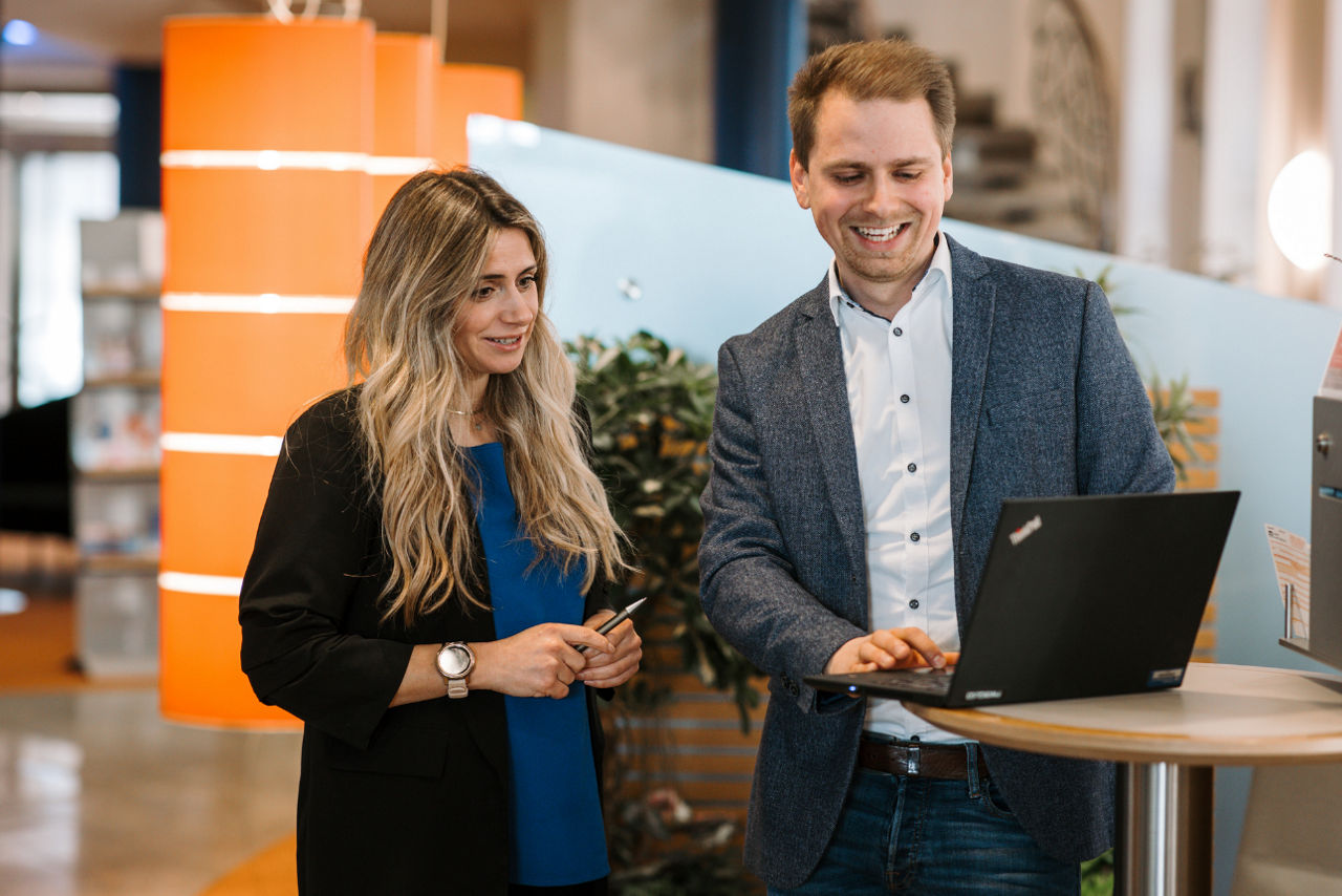 Ein Mann und eine Frau schauen gemeinsam auf einen Laptop