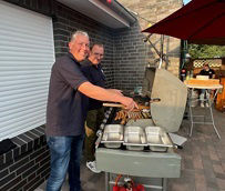 Zwei Mitarbeiter am Grill im Garten