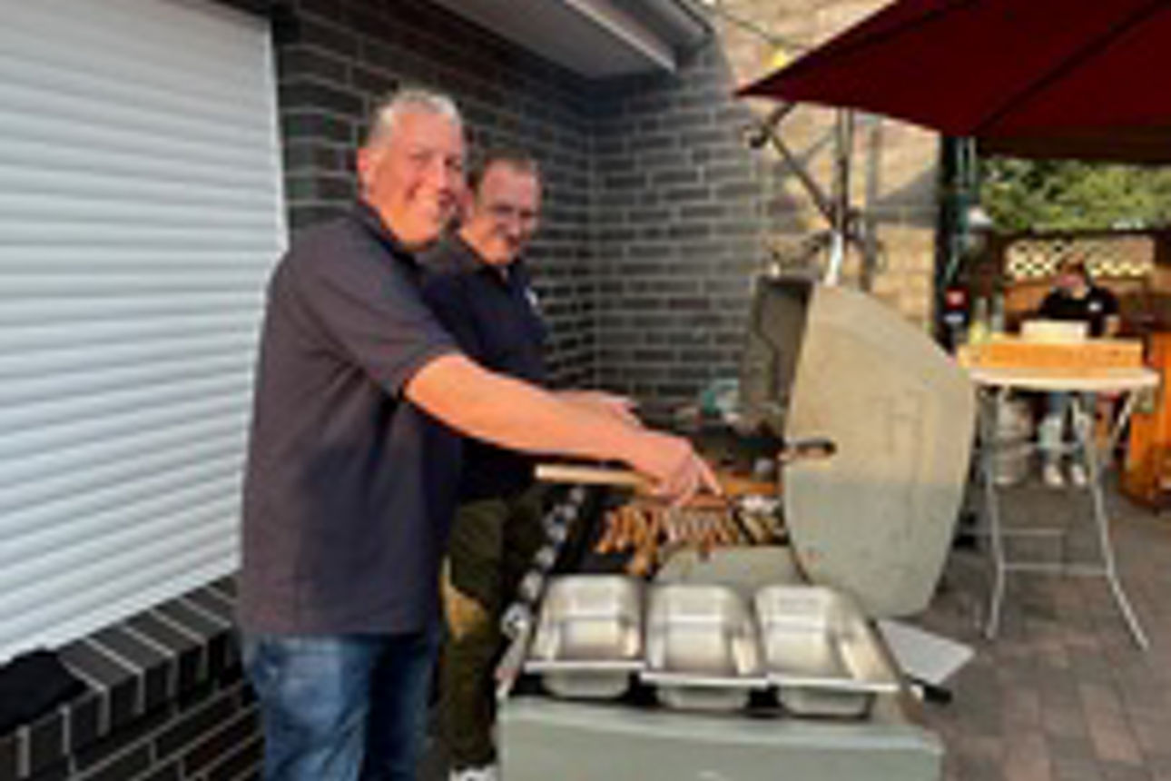 Zwei Mitarbeiter am Grill im Garten