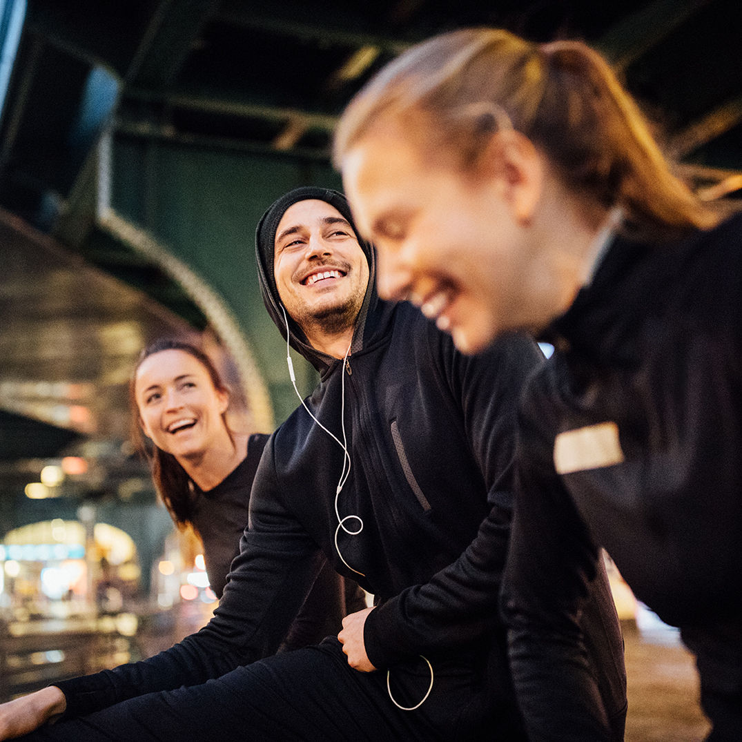 Junge Menschen sitzen nebeneinander und lachen