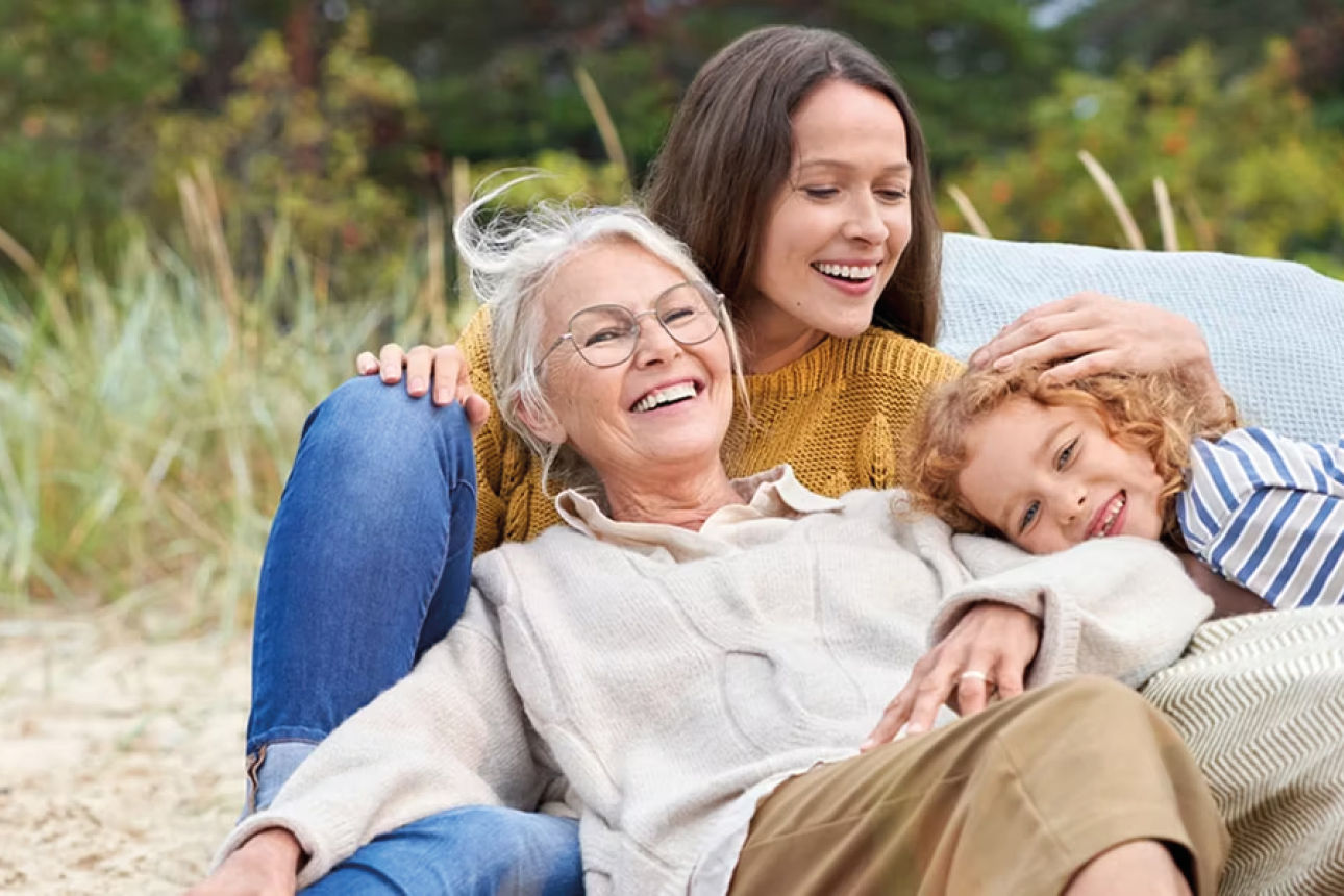 Sie sehen eine Mutter, ein Kind und eine ältere Frau, liegend auf einer wiese. 