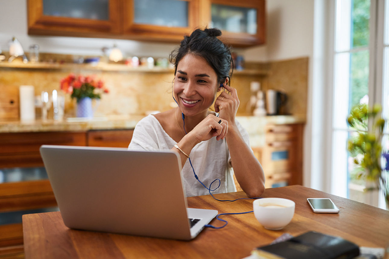 Eine Frau arbeitet in der Küche an einem Notebook