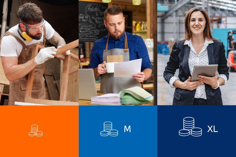 Älterer und jüngerer Mann stehen in einer Arbeitshalle und besprechen Arbeitsdokumente