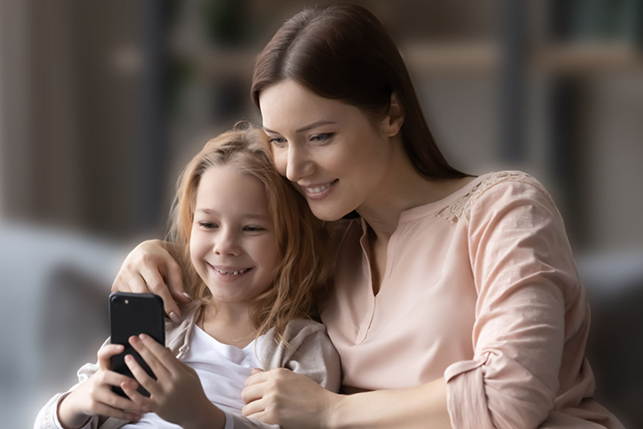 Zwei Jugendliche im Bus schauen auf ein Smartphone