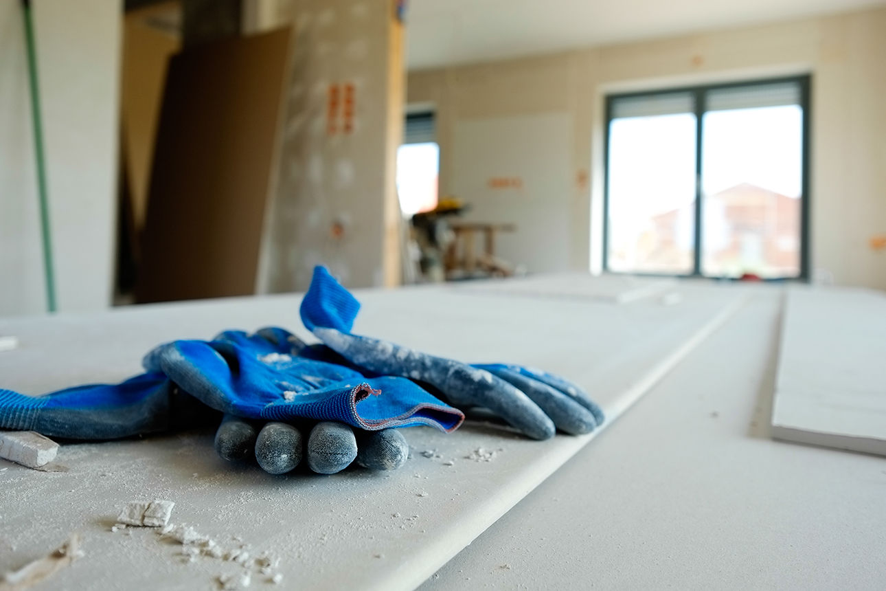Blaue Arbeits-Handschuhe liegen auf einer Baustelle