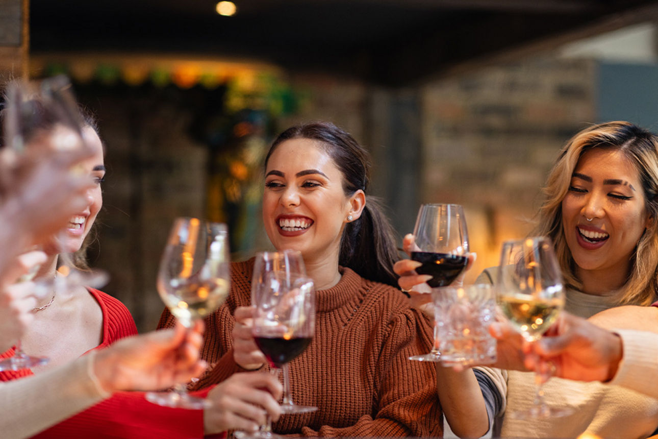 Frauen die mit Wein anstoßen