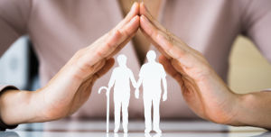 Schützende Hände über zwei älteren Personen