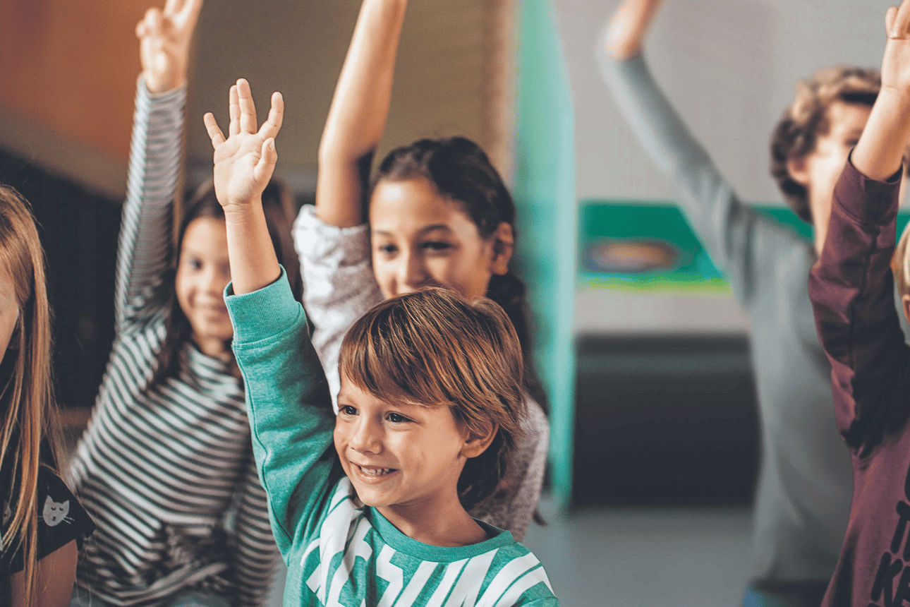 Aufzeigende Kinder im Klassenraum