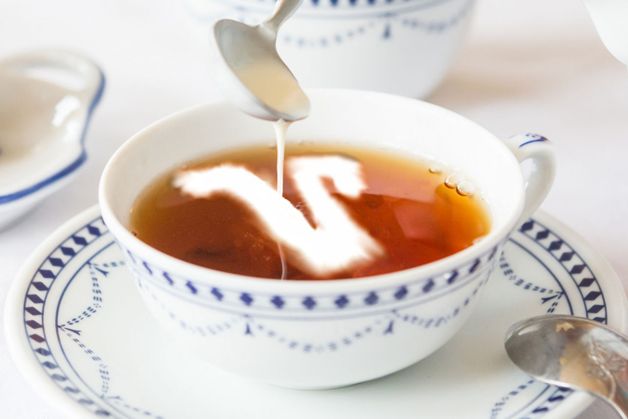 Teetasse mit dem Logo der Raiffeisen-Volksbanken aus Sahne im Tee 