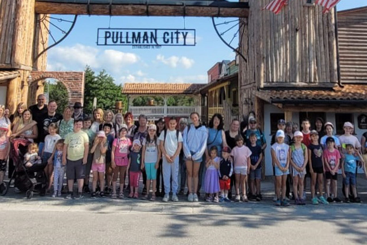 Alle Teilnehmer stehen vor dem Eingang zu PullmanCity zum Gemeinschaftsfoto