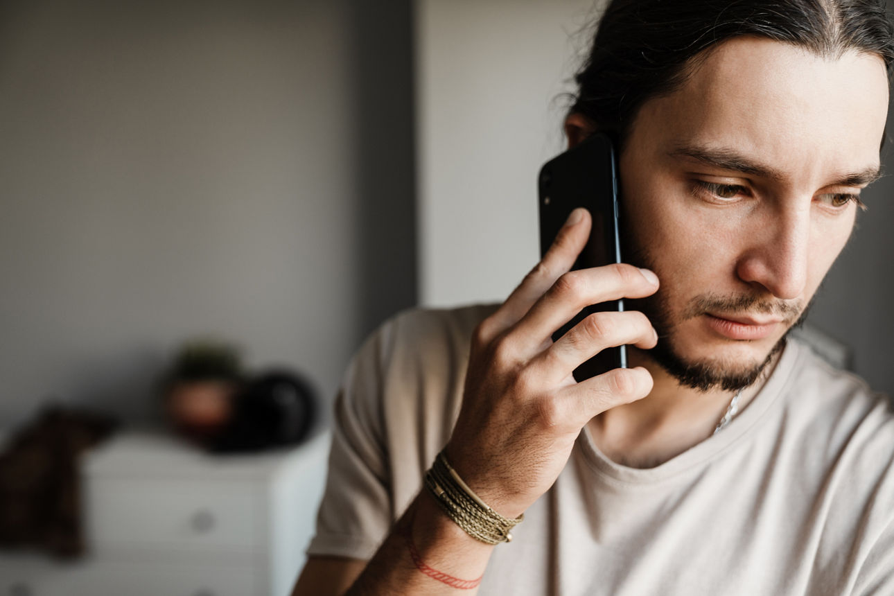 Ein Mann führt ein bedrückendes Telefongespräch