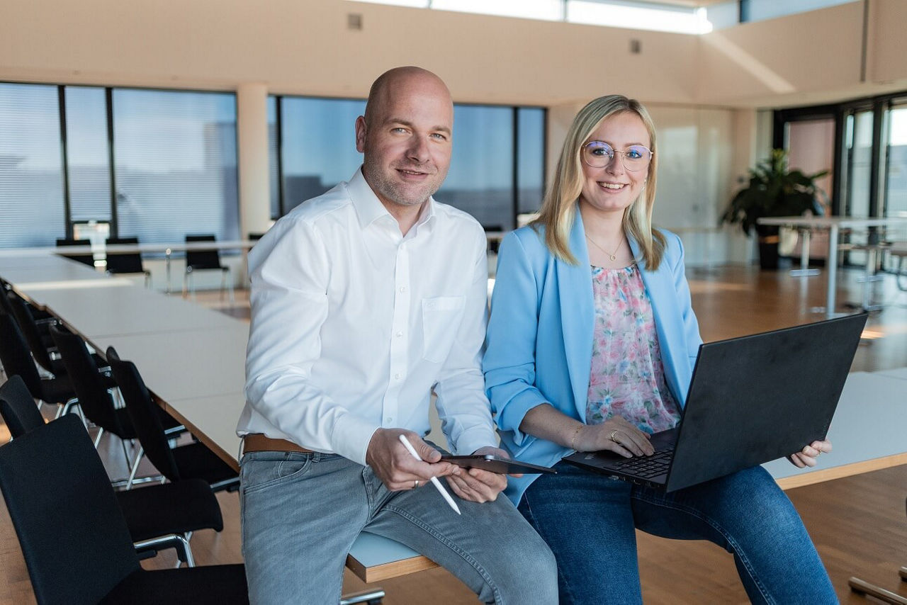 Zwei Mitarbeitern arbeiten gemeinsam am Laptop.