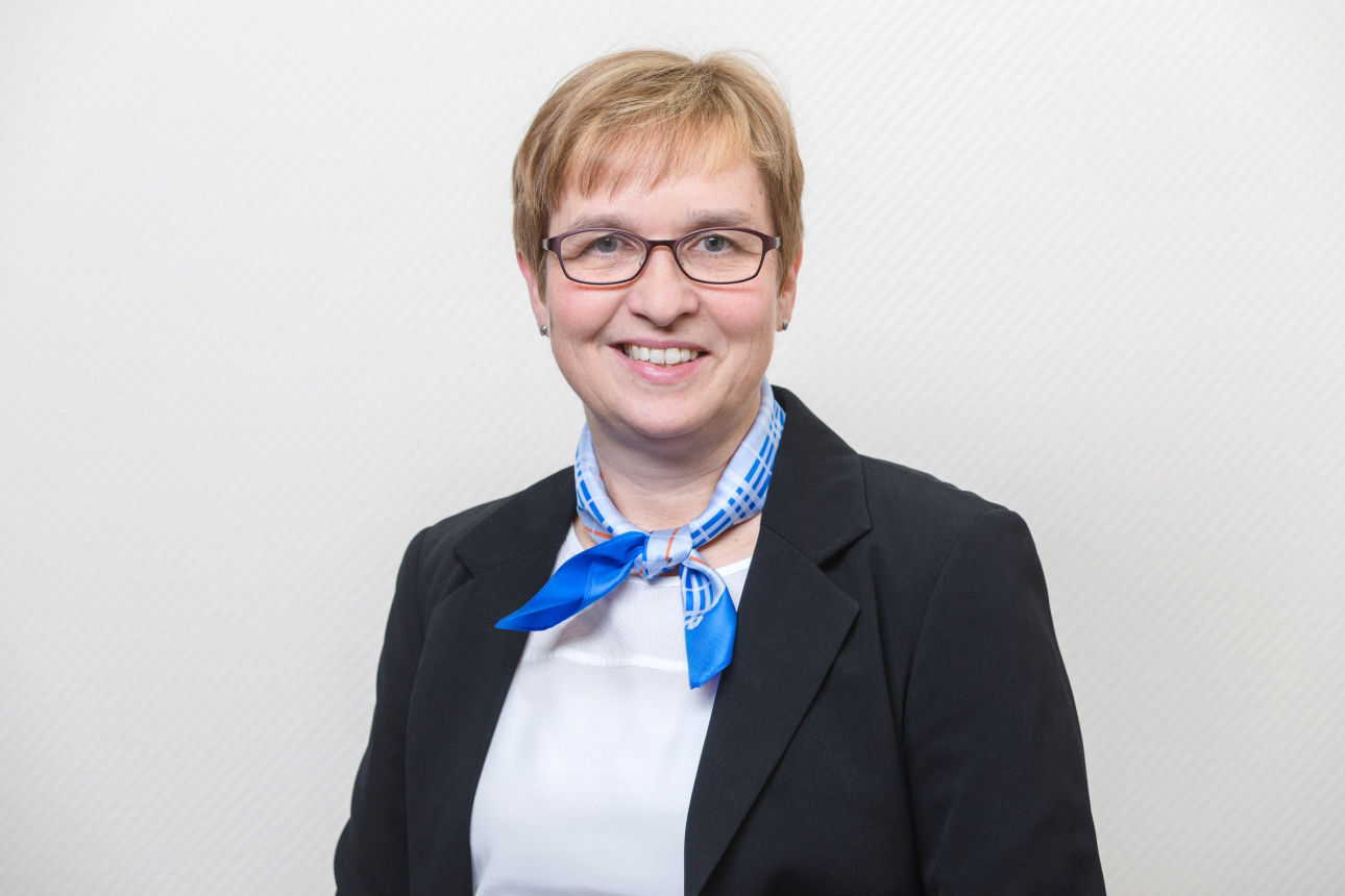 Eine lächelnde Frau schaut in die Kamera.