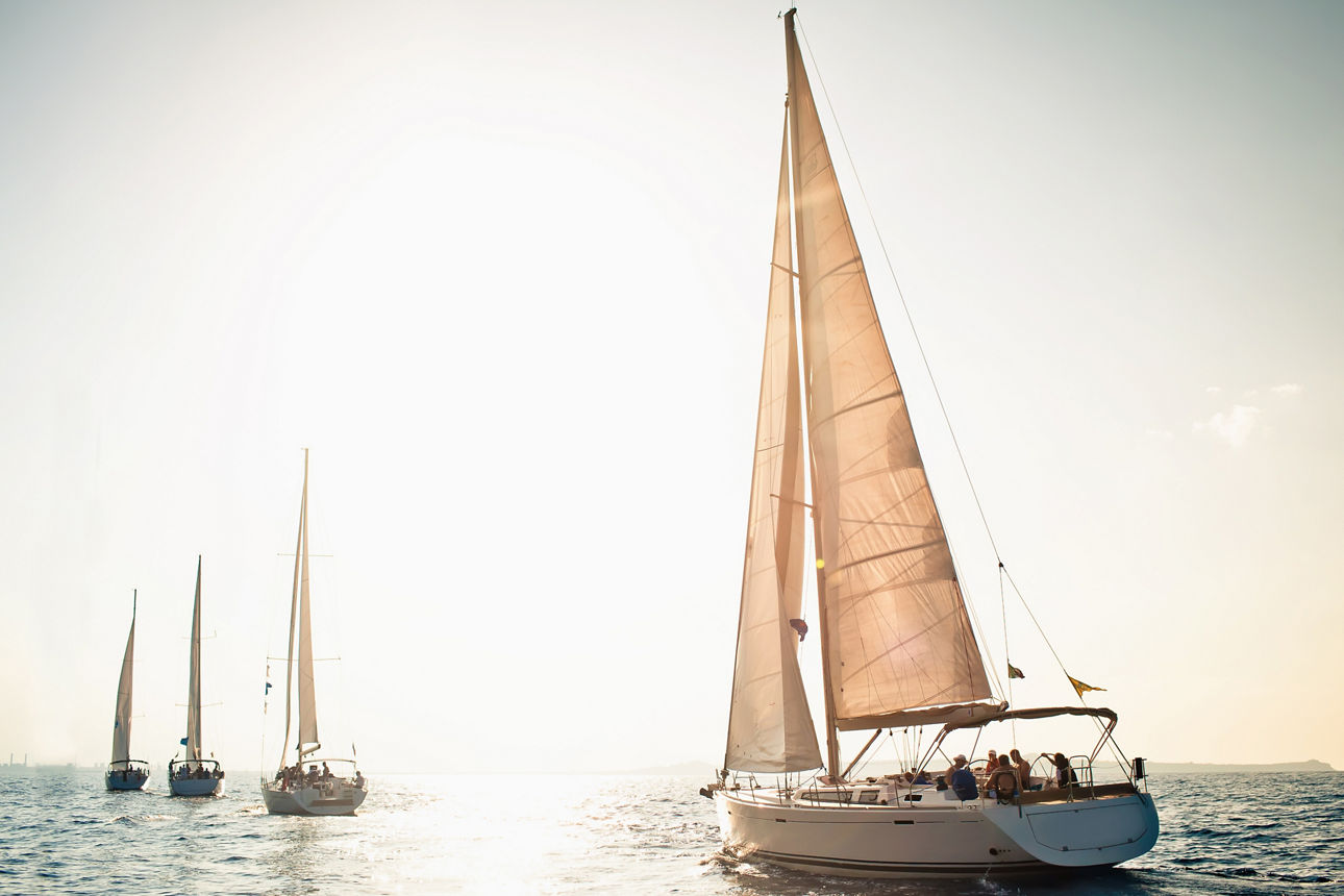 Sailing ship yachts with white sails at the open sea