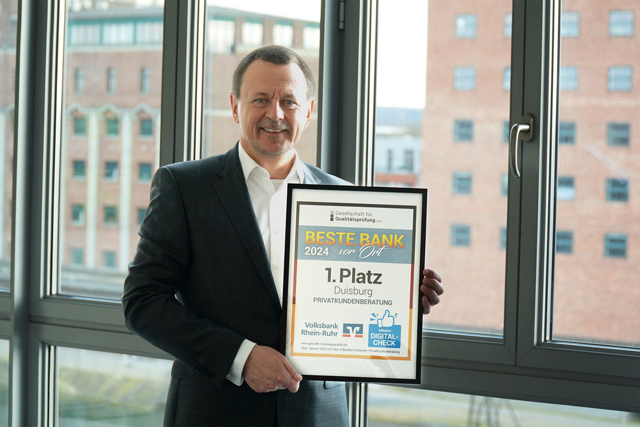 Vorstand hält die Auszeichnung zur Besten Bank in Duisburg 2024 in der Hand.