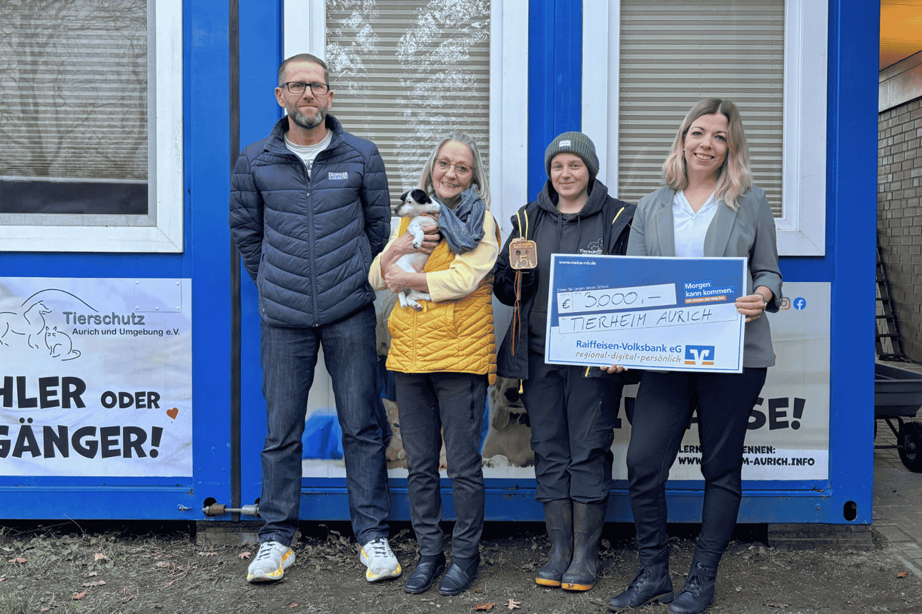 Vier Personen bei symbolischer Scheckübergabe 