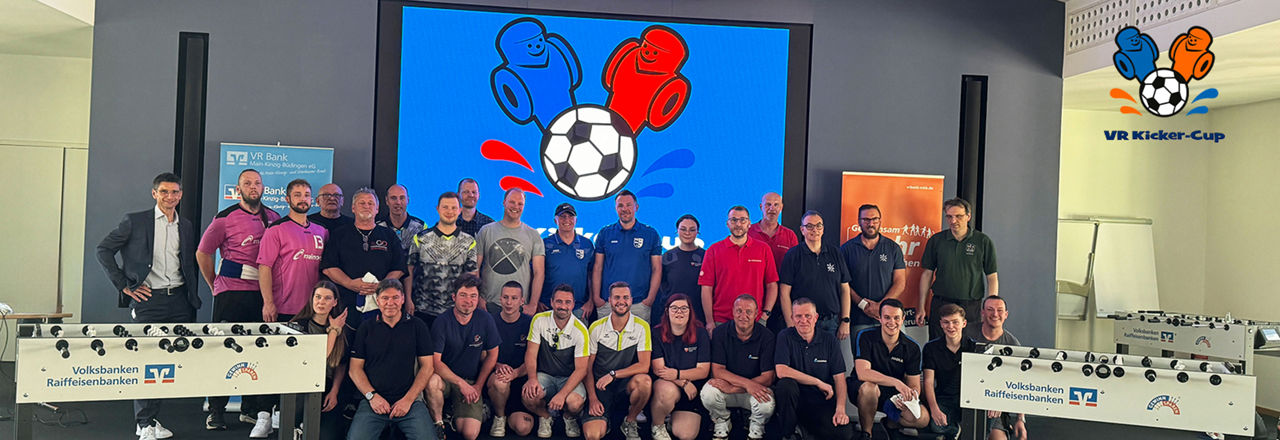 Das Bild zeigt ein Gruppenfoto vom VR Kicker Cup im VR-DialogForum. Teilnehmer lächeln stolz.