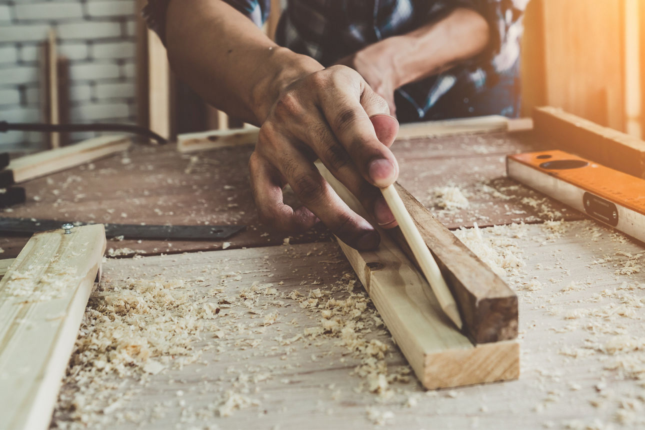 Carpenter working on wood craft at workshop to produce construction material or wooden furniture.