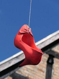 Ein roter Schuh hängt an einem Draht