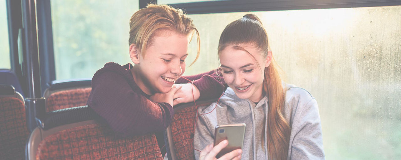 Junge und Mädchen schauen auf Smartphone