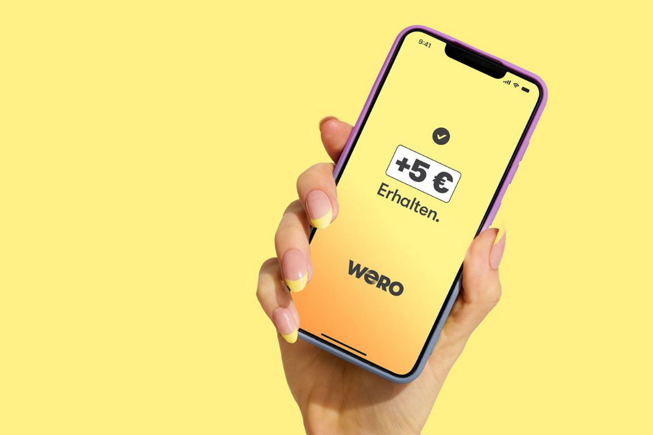 ein in der Hand gehaltenes Smartphone zeigt eine 5 EUR Gutschrift in der Wero-Anwendung