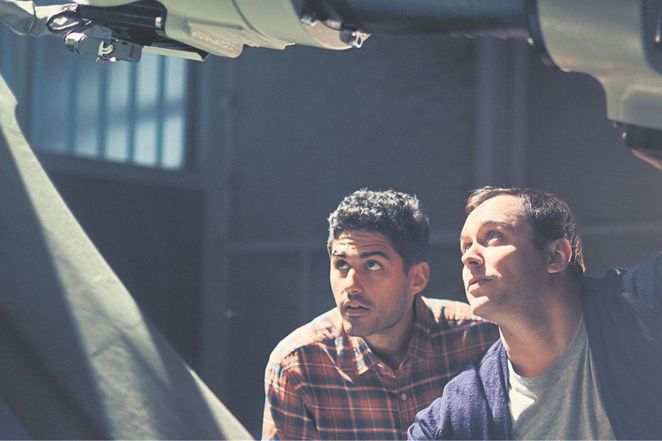 Zwei Männer arbeiten an einem Roboterarm